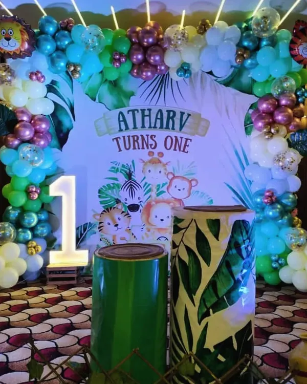 This is one of our most requested themes, a full Jungle Safari setup for a first birthday. I used a custom backdrop with the birthday boy's name, a large light-up number '1', and themed pedestals to create a complete photo-ready zone.