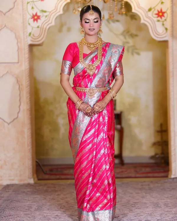 A full-length portrait of our stunning South Indian bride. The pink and silver Kanjeevaram saree is paired with classic temple jewelry and a clean, elegant makeup look.