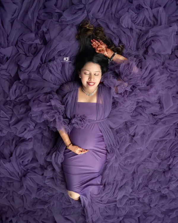 A unique overhead shot, with the mom-to-be looking serene in a sea of purple tulle. This artistic portrait is one of my favorite ways to showcase the beauty of pregnancy.