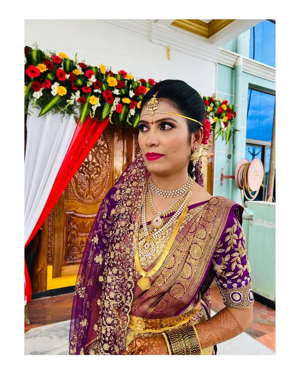 A classic South Indian muhurtham look. I focused on creating a flawless, radiant base that lasts through all the rituals, paired with a bold magenta lip and defined eyes to complement her stunning purple and gold Kanjeevaram saree.