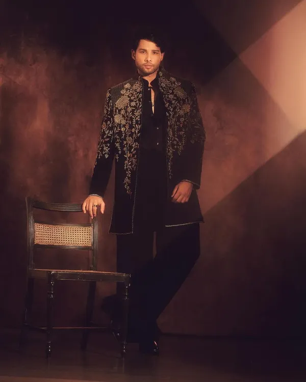 Siddhant Chaturvedi in a magnificent Tarun Tahiliani jacket for Diwali. The intricate floral embroidery on the dark fabric is a perfect example of modern festive wear that is both opulent and tasteful.