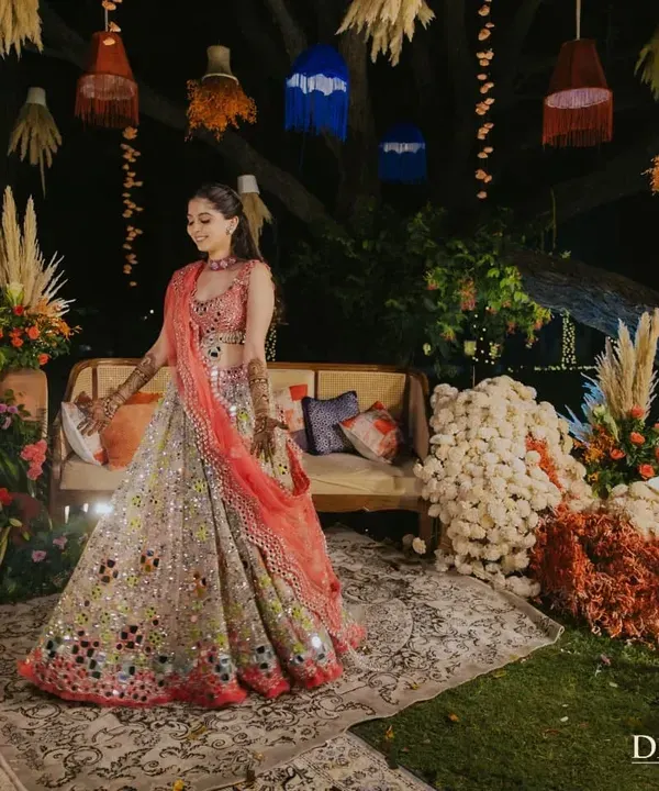The bride, radiant in her colorful lehenga, at her Marrakesh-themed Mehendi. The decor, with its hanging lanterns and vibrant florals, created the perfect backdrop for her grand entrance.