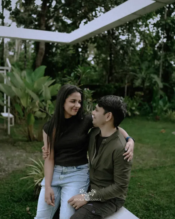 A casual, sweet moment between a couple, sharing a look of love in a beautiful garden setting.