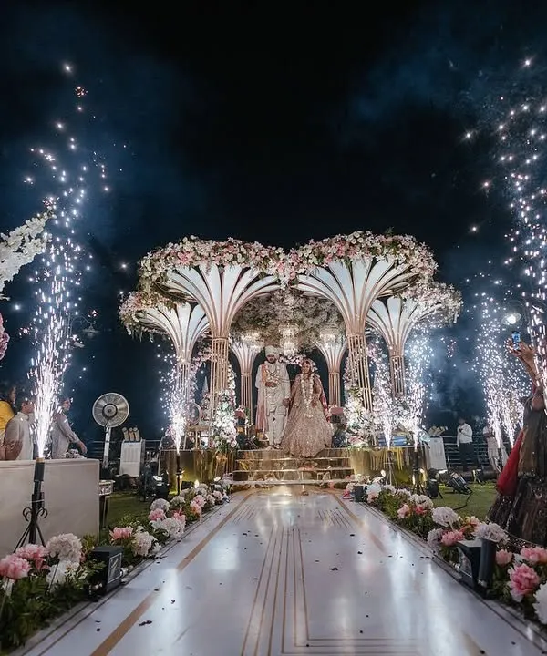 A breathtaking varmala moment for Yasha and Rahil, set against the sea. We designed this see-through mandap with blush florals and a baby's breath ceiling to create a truly magical space where love, beauty, and nature could intertwine.