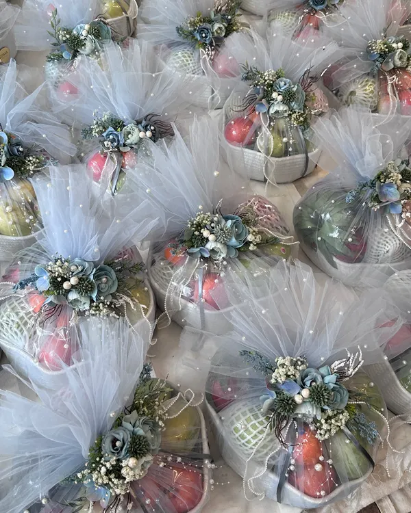 These beautiful fruit baskets, wrapped in delicate blue tulle with floral accents, are a perfect example of a luxurious and healthy wedding favor. It’s an elegant way to thank your guests for being a part of your celebration.