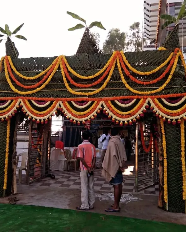 This grand *chappra* is a perfect example of traditional event decor for a housewarming. Woven from coconut leaves and adorned with marigold garlands, it provides an impressive and auspicious welcome right at the entrance of the home.