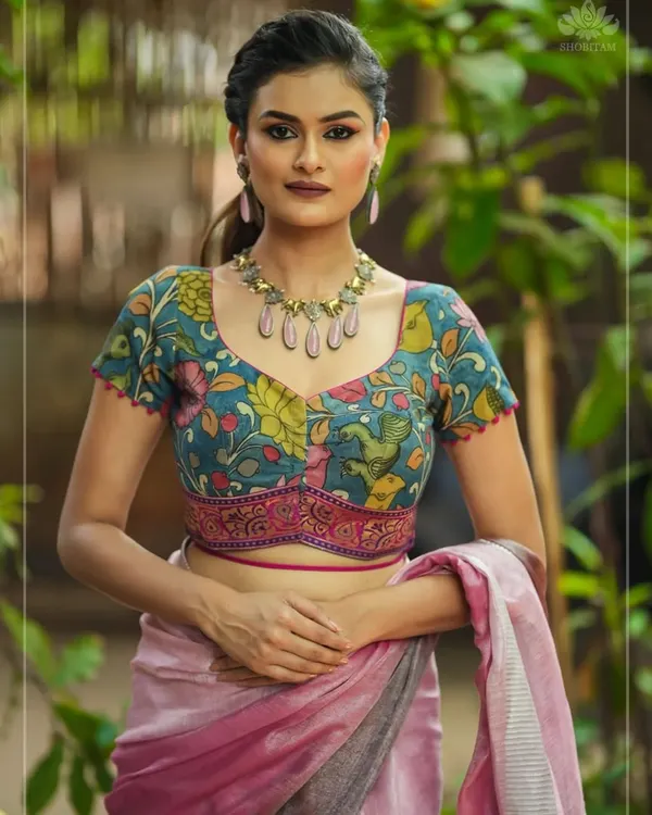 This look is all about harmony. The model wears a stone-drop necklace with colors that perfectly echo the floral Kalamkari print of her blouse, creating a cohesive and artistic statement.