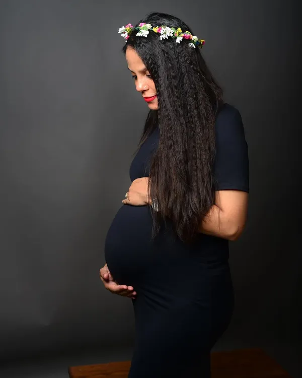 A serene and beautiful solo maternity portrait. The flower crown adds a soft, natural touch to this classic profile shot celebrating motherhood.
