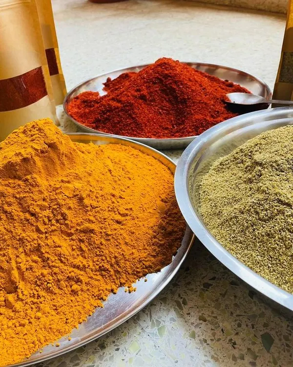 The secret to authentic flavor is in the spices. I source these vibrant, hand-ground masalas directly from Rajasthan. You can see the rich color and texture of the turmeric, red chili, and coriander powders.