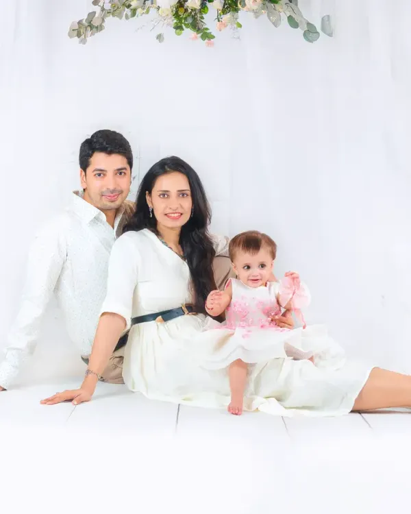 A beautiful family portrait session featuring parents and their baby girl, styled in coordinating white outfits for a clean and classic look.