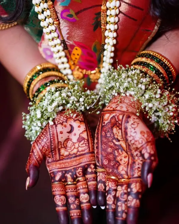 A beautiful shot of a baby shower mehndi with a rich, dark stain. The design includes a baby sleeping under the moon, celebrating the new life to come.