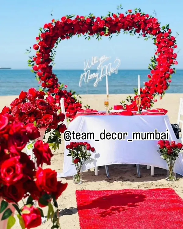 We create unforgettable moments, like this breathtaking beachside marriage proposal. The heart-shaped arch of red roses against the ocean backdrop provides the perfect setting to ask the most important question.