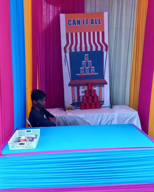 A classic 'Can It All' tin can toss stall, perfect for bringing a carnival feel to your event. I provide the complete setup with the stall, backdrop, and game materials.