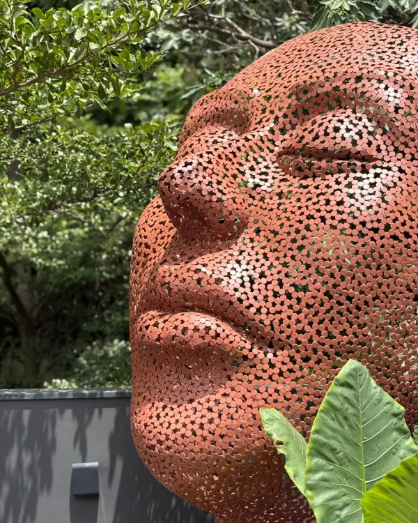 'The Stillness' is a portrait of quiet power, crafted from perforated mild steel. Placed outdoors, this monumental head becomes a part of the landscape, its serene expression offering a point of reflection amidst the chaos of daily life.