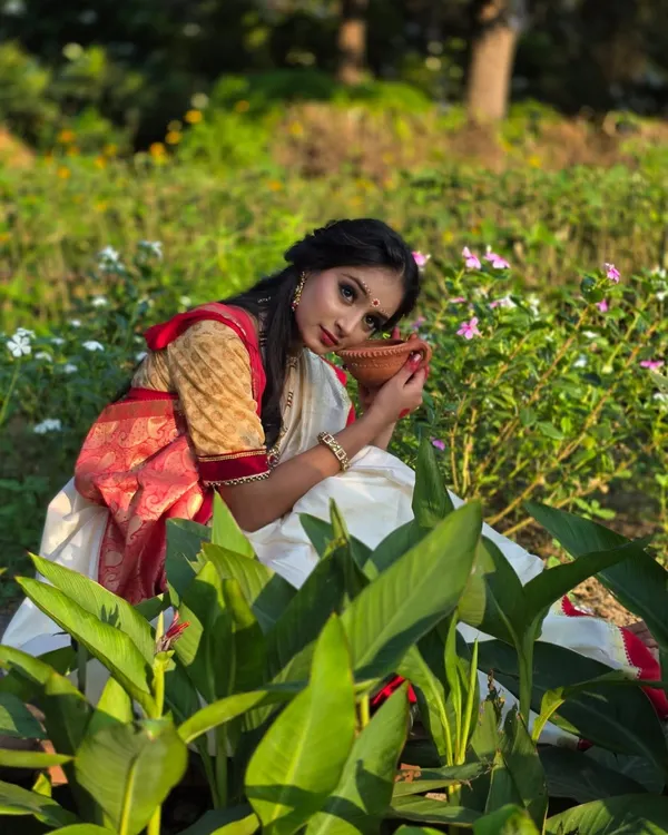 A beautiful portrait from a Bengali-themed shoot in a garden. The soft light and natural surroundings perfectly complement her traditional attire, creating a look straight out of a movie.