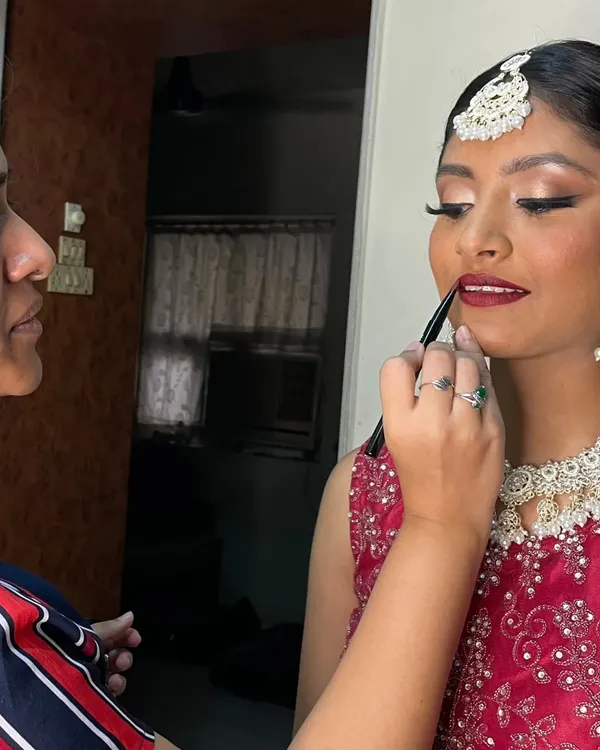 The final touch. Applying the perfect shade of red lipstick to complete this bride's glamorous look. It's these small details that bring everything together.