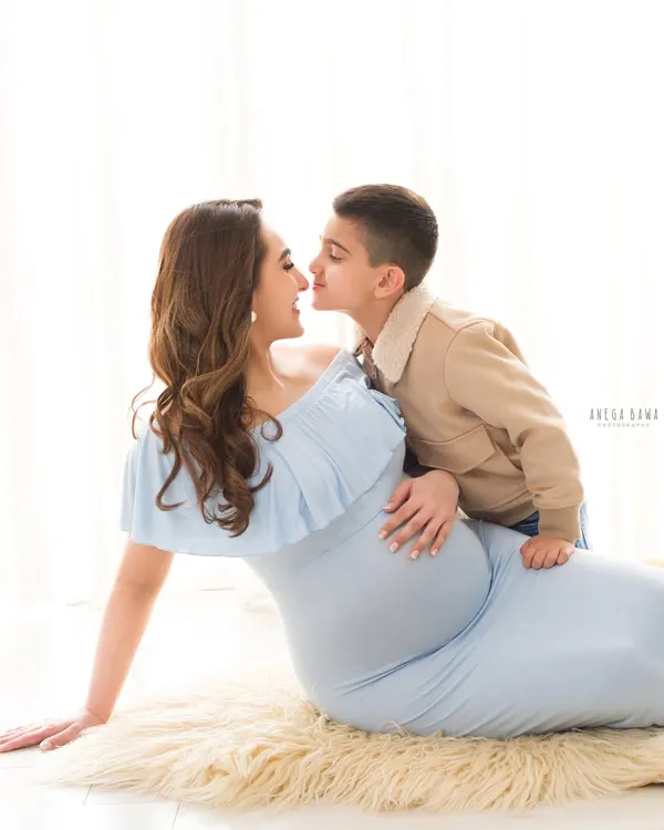 A tender moment between a mother-to-be and her son. This light and airy maternity portrait captures the sweet connection as they await the new baby.
