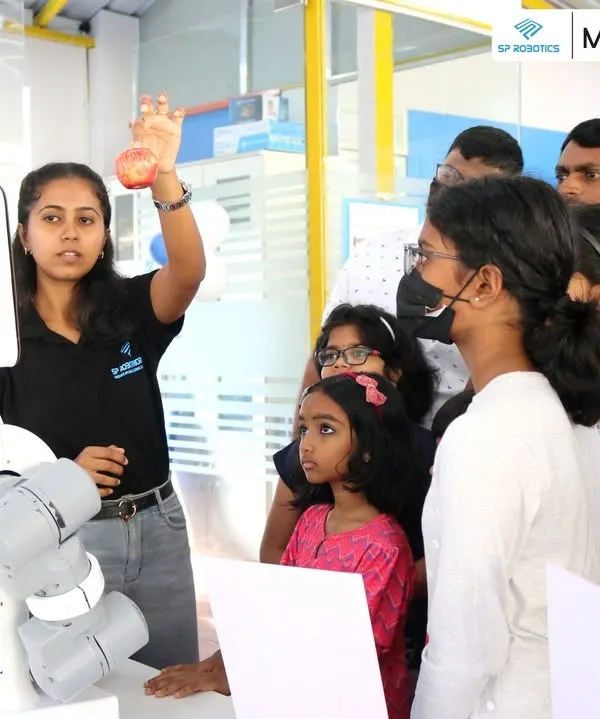 An instructor from our team demonstrates the capabilities of a robotic arm to an engaged audience at our Maker Lab. Our workshops are interactive, encouraging questions and direct participation.