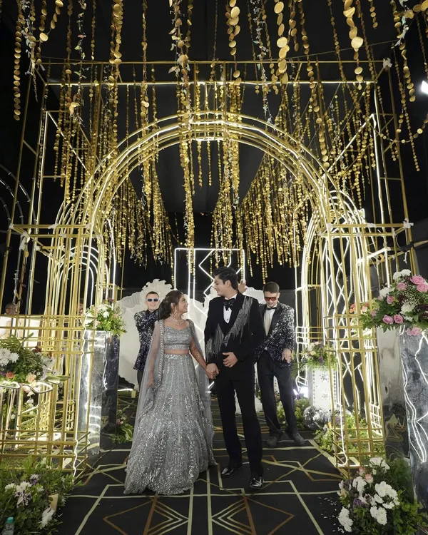 A grand Sangeet entrance that feels like a movie premiere. We designed this golden Gatsby-themed tunnel to give the couple a spectacular welcome to their party.