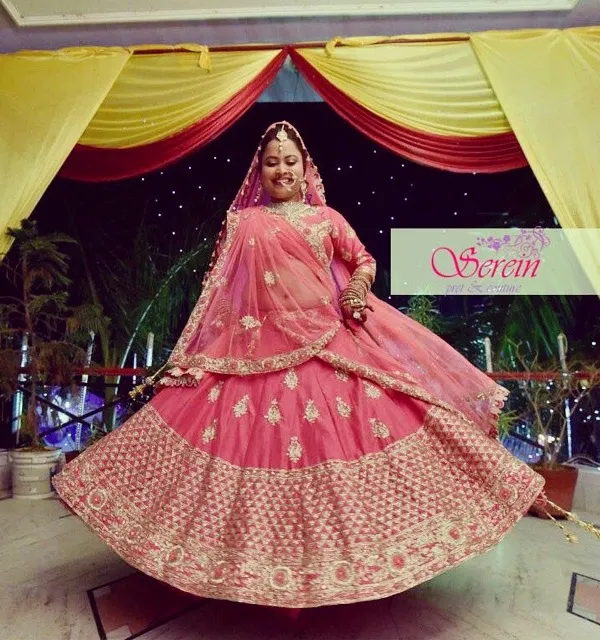 A twirl of happiness from a beautiful bride in her custom-designed Serein lehenga. This pink and gold creation features extensive zardozi embroidery, designed to make her big day absolutely unforgettable.