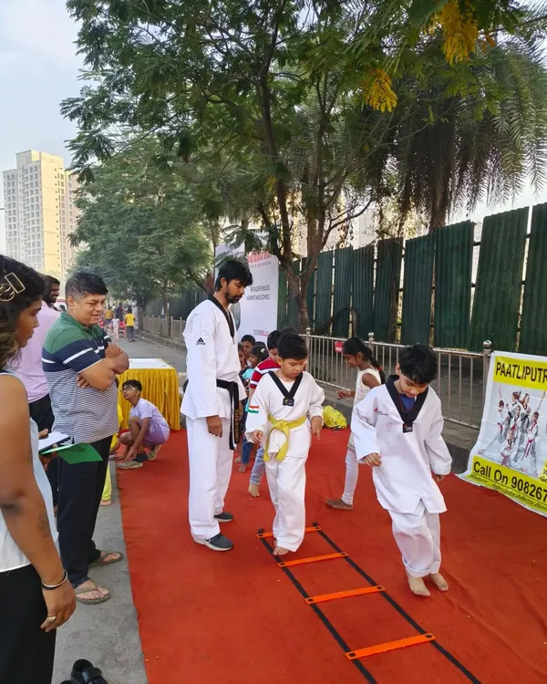 Taking our training outdoors. A young student practices on an agility ladder during our session at the Malad Masti event, showing that we can build skills anywhere.