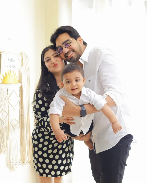 A bright and happy family portrait taken in our indoor studio. The classic black and white outfits and the simple, light-filled setting create a timeless look.