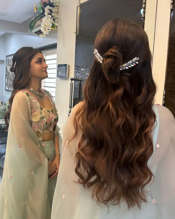 A beautiful half-up style featuring a knotted bun and soft waves. I added two sparkling, leaf-shaped clips to frame the bun, creating a look that is both elegant and modern. This is perfect for an engagement or reception.