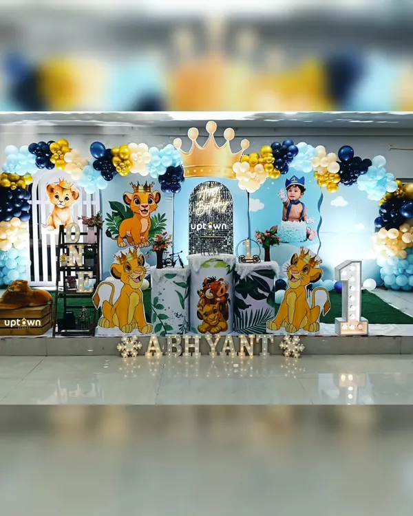 This is the kind of grand, exciting setup we love to create for a child's first birthday. For this Lion King theme, we used a custom backdrop, a multi-layered balloon arch in blue, yellow, and gold, and life-sized character cutout's of Simba and his friends to bring the jungle to life.
