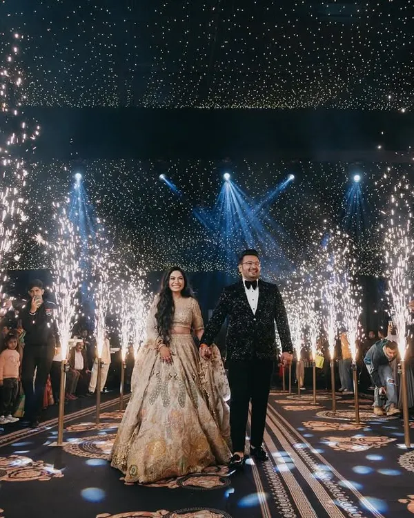 Tushar and Samta make a grand entrance at their reception, walking through a tunnel of sparklers. This shot is all about glamour, celebration, and making a spectacular entry.