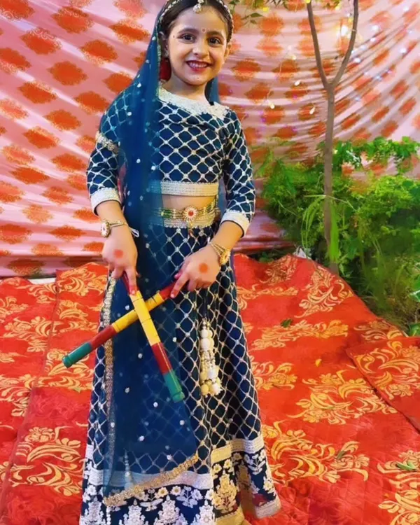Our little performer dressed as Radha, holding dandiya sticks for a festive Janmashtami dance number. We pay close attention to costume details to make every child's performance special.