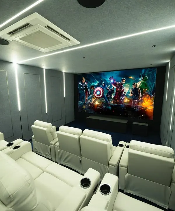 I design and build immersive home cinemas that are a true escape. This modern theater in Madurai features multiple rows of plush, white leather recliners, a massive 4K projection screen, and a fully integrated Dolby Atmos sound system for an unparalleled viewing experience.