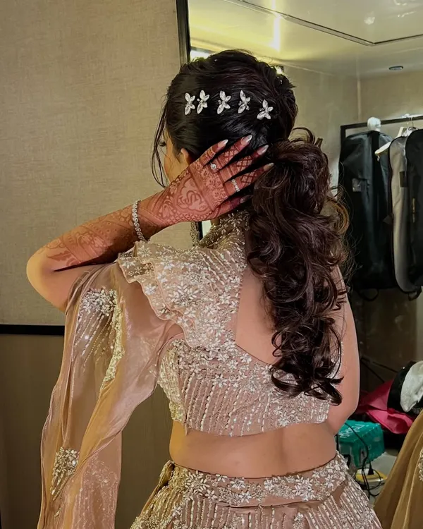 A back view of this elegant Sangeet ponytail, showing the volume and texture of the curls.