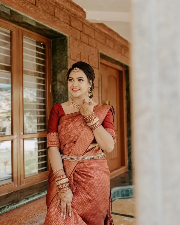 A beautiful portrait of a bride-to-be at her engagement. She is wearing a rich maroon saree, and her makeup is kept soft and radiant to celebrate the happy occasion.