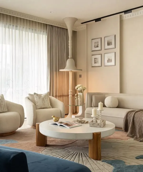 The KAIA living space is a warm and inviting sanctuary, where we curated a circular seating arrangement to foster connection. Neutral-toned boucle fabric sofas and armchairs were custom-designed, their soft textures complementing the serene ambiance, while a deep blue loveseat adds a striking yet elegant accent.