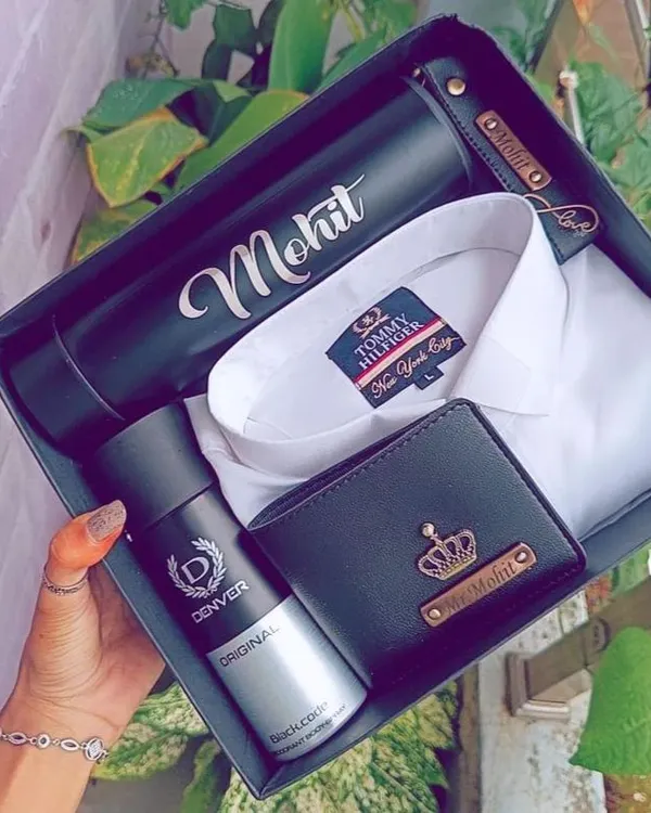 A classic combination for any man. This hamper features a crisp white Tommy Hilfiger shirt, a personalized leather wallet, a name-engraved flask, and a Denver deodorant, all ready to gift.