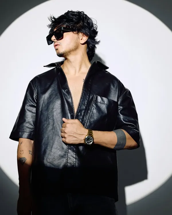 A shot from my 2025 press kit session. This look, with the leather shirt and sunglasses, captures my edgy and modern artist persona.