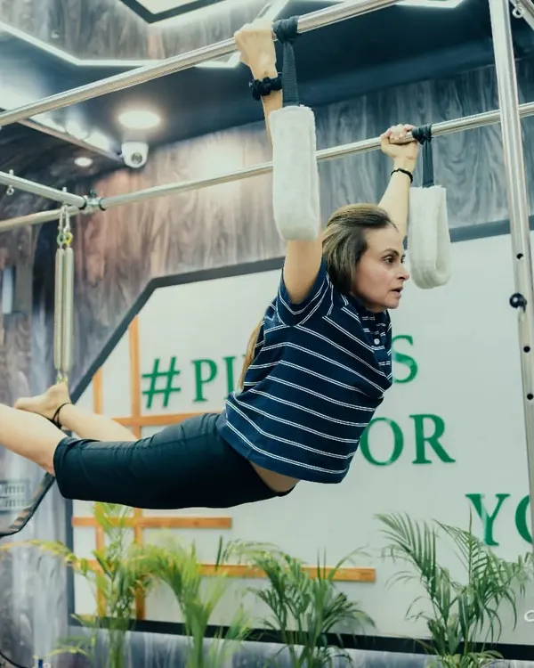 This hanging exercise on the Cadillac is an advanced movement that builds incredible upper body and core strength, demonstrating the principle of controlled, centered movement.