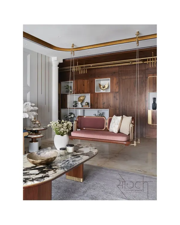This living room from the Crescendo House captures my approach to creating spaces that are both grand and personal. The custom-designed reversible swing, crafted from teak and brass, serves as a unique centerpiece, blending artistry with everyday function against a backdrop of rich wood paneling and luxurious marble.