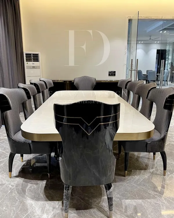 An opulent 10-seater dining set. The table features a lustrous white onyx top with a brass-trimmed base, surrounded by high-back chairs with unique cut-out details and dual-fabric upholstery.