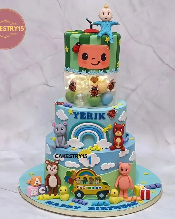A spectacular three-tier Cocomelon cake for a first birthday. This 5kg choco-vanilla creation features a light-up spacer, fondant characters, and a vibrant, playful design.