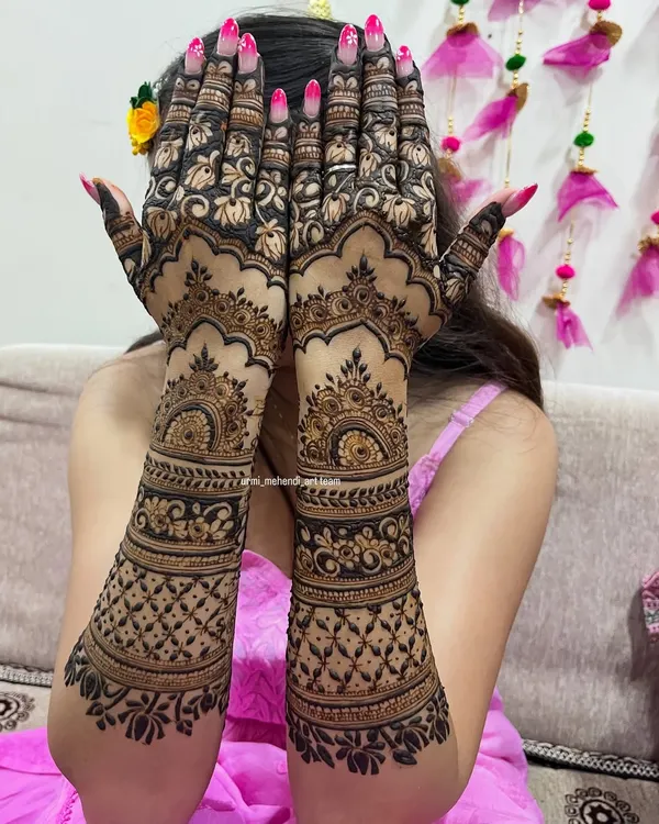 A full coverage back-hand design that is bold and beautiful. The contrast between the dark, filled-in floral patterns and the delicate net-like details creates a striking effect, perfect for a bride who wants to make a statement.