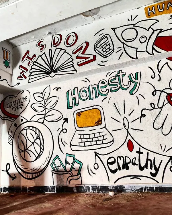 A section of the doodle mural for a CA students' hostel, featuring words like "Wisdom," "Honesty," and "Empathy." The design combines motivational text with playful icons like a rocket and a laptop to create a visually engaging and inspiring environment.