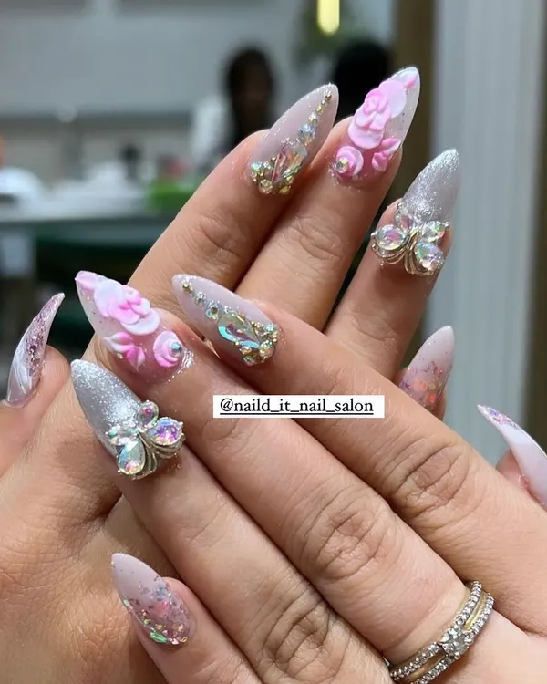 A showcase of our intricate 3D capabilities. This set features hand-sculpted pink acrylic flowers and sparkling butterfly charms made of Swarovski crystals on long stiletto extensions.