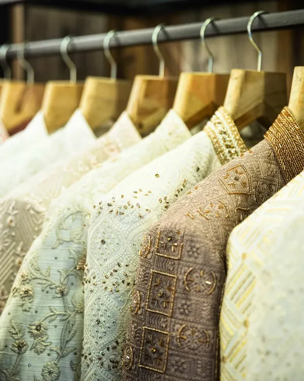 A rack of my creations, showcasing a variety of fabrics, colors, and intricate embroidery. Each piece is crafted to perfection, waiting to become part of a modern man's story.