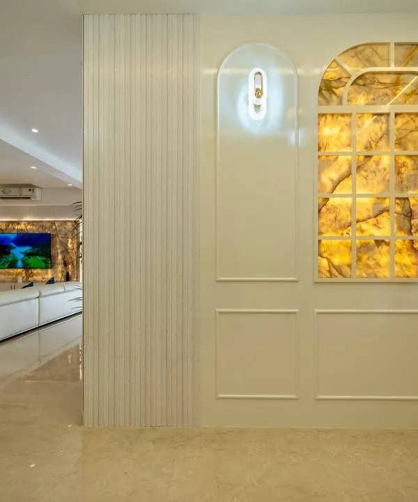 This wall exudes luxury with its stunning backlit onyx panel, designed to look like a window. The warm, ambient glow highlights the stone's natural veins, creating a captivating focal point that is both artistic and elegant.