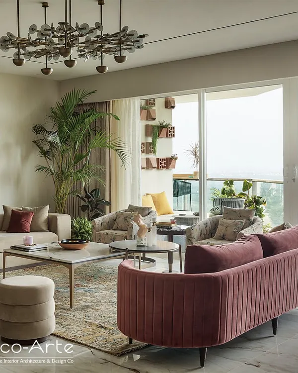 This living room is a voyage of design discovery, featuring a curved pink velvet sofa and a modern chandelier. The space is designed to tell a story, with every detail speaking volumes about refined taste.