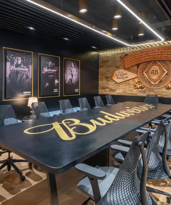 This Budweiser conference room is a great example of how I integrate a brand's identity directly into the workspace. The hand-painted logo on the table and the custom mural reflecting the brand's heritage create a powerful, immersive environment that's far more impactful than a simple logo on a wall.