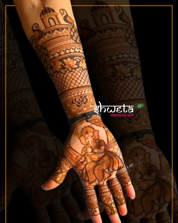 A beautiful dancing Ganesha figure on the palm, bringing blessings to the bride. Creating divine figures is a specialized skill I teach in my professional course.