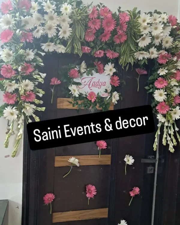 I created this custom floral arch to welcome home a newborn baby named Aadya. It is made with fresh pink and white gerberas and fragrant rajnigandha, designed to fit perfectly around the family's front door for a memorable celebration.
