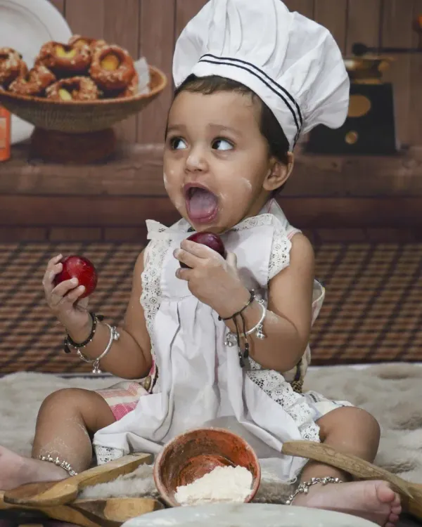 This is the kind of fun, natural moment I love to capture. I bring all the props and costumes, like for this little chef theme, right to your home so your child is comfortable and we can get genuine expressions.